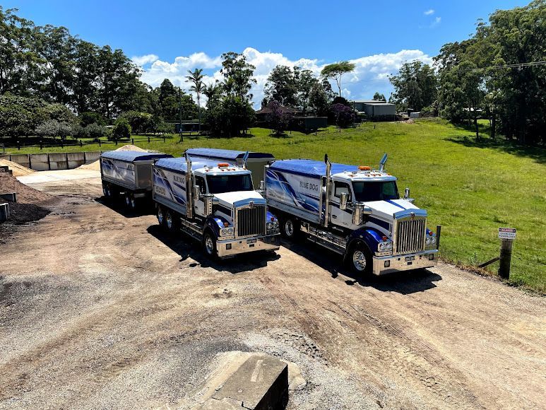 Three Dump Trucks Are Parked Next To Each Other On A Dirt Road — Blue Dog Landscape Supplies In Newee Creek, NSW