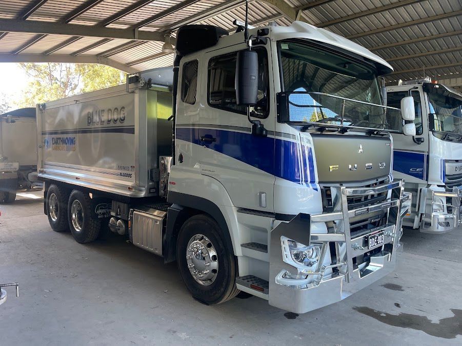 Two Trucks Are Parked Under A Roof In A Parking Lot — Blue Dog Landscape Supplies In Newee Creek, NSW