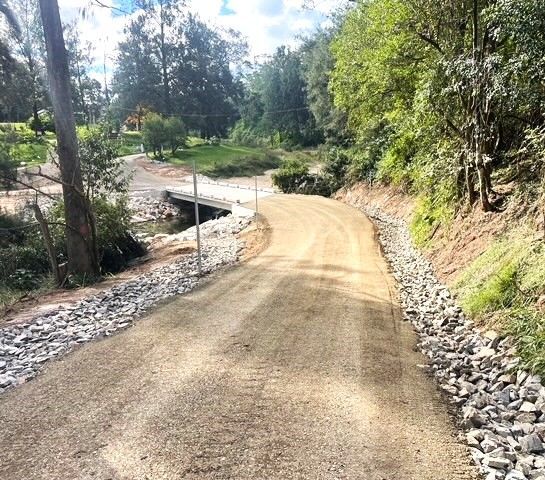A dirt road going through a forest with a bridge in the background — Blue Dog Landscape Supplies In Newee Creek, NSW