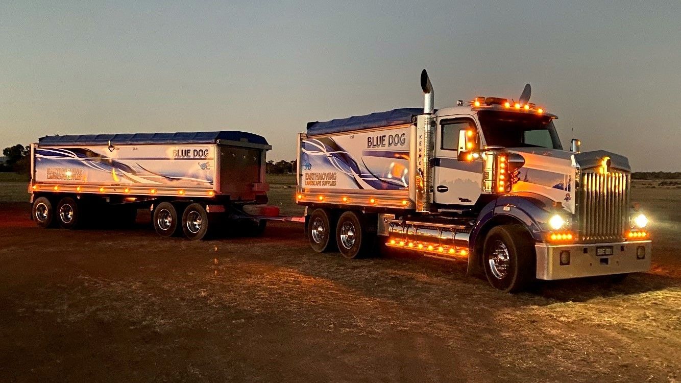 A semi truck with a trailer attached to it is parked in a field — Blue Dog Landscape Supplies In Newee Creek, NSW