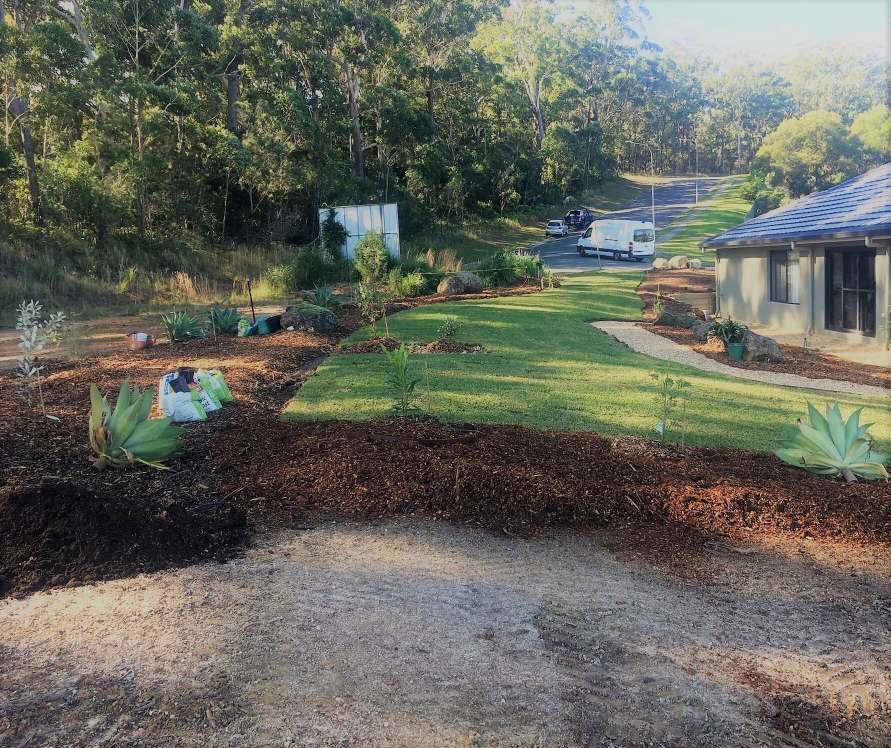 A House Is Sitting On Top Of A Lush Green Hillside Surrounded By Trees — Blue Dog Landscape Supplies In Newee Creek, NSW