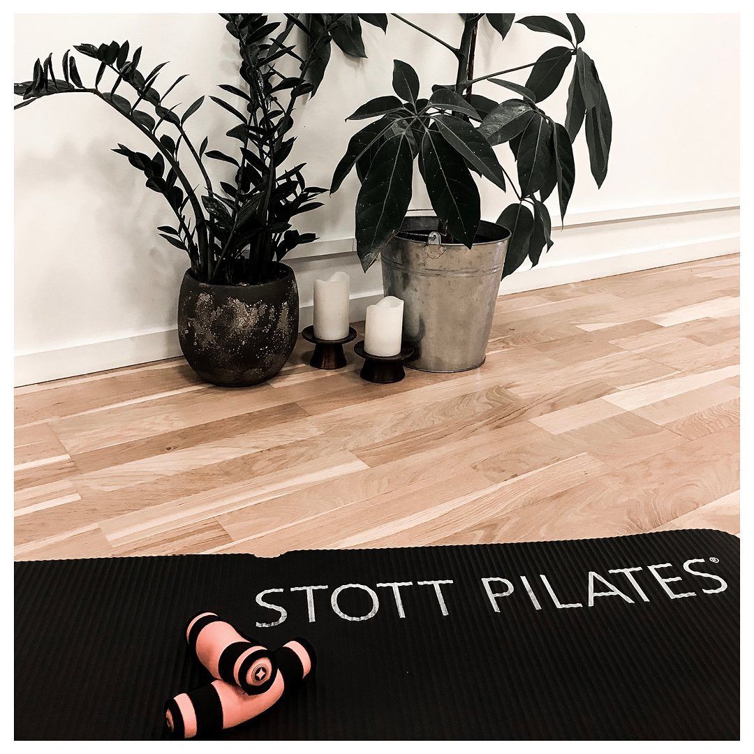 A black mat that says ' stott pilates ' on it