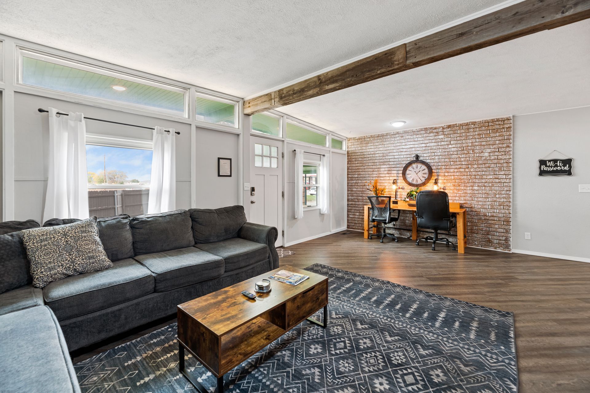 A living room with a couch , coffee table , and desk.