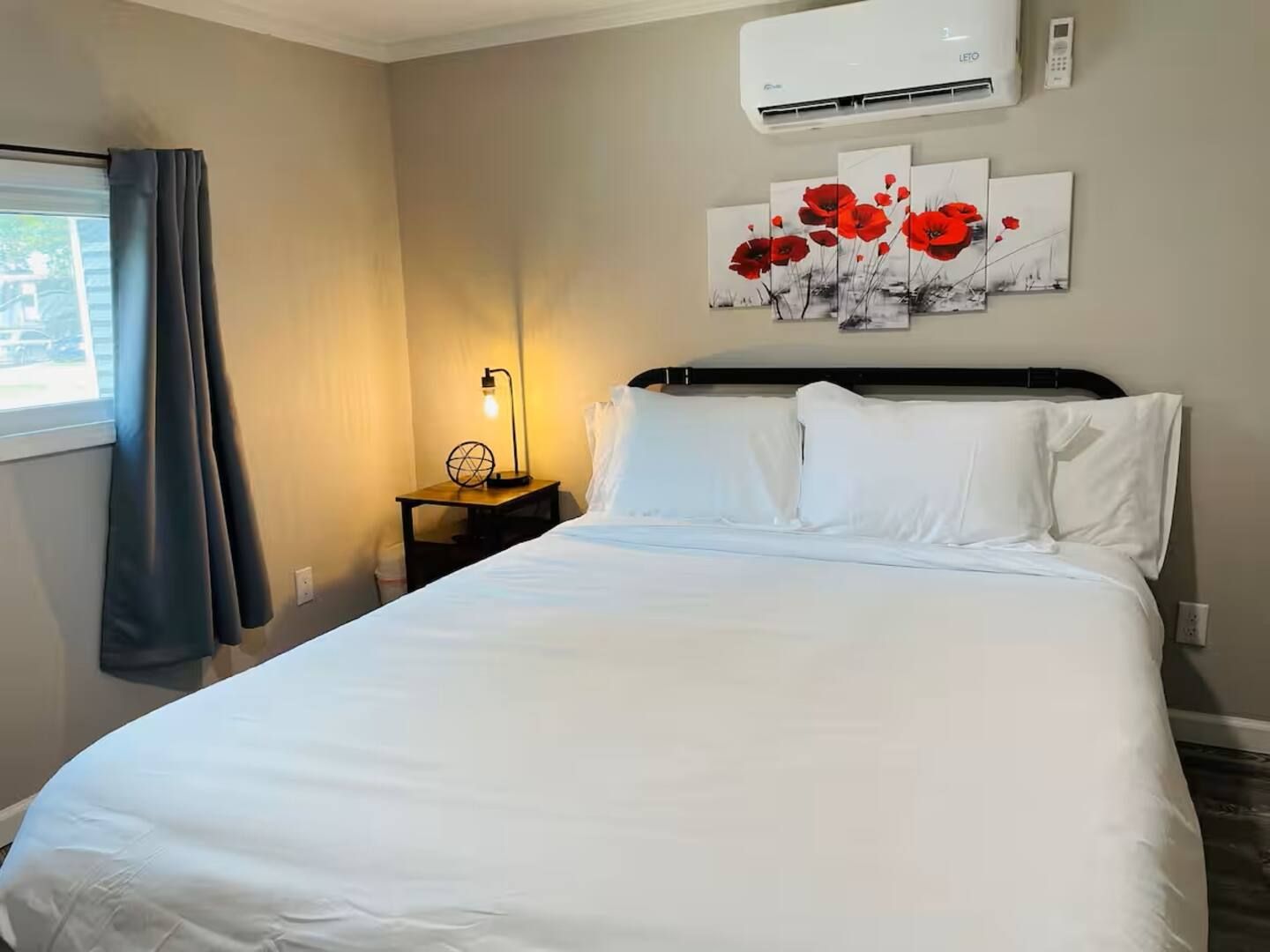 A bedroom with a bed and a painting on the wall.