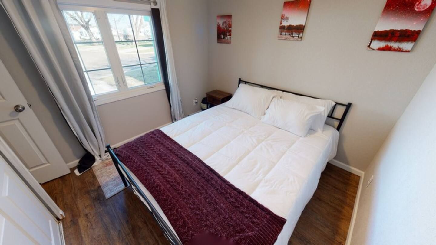 A bedroom with a bed and a window.