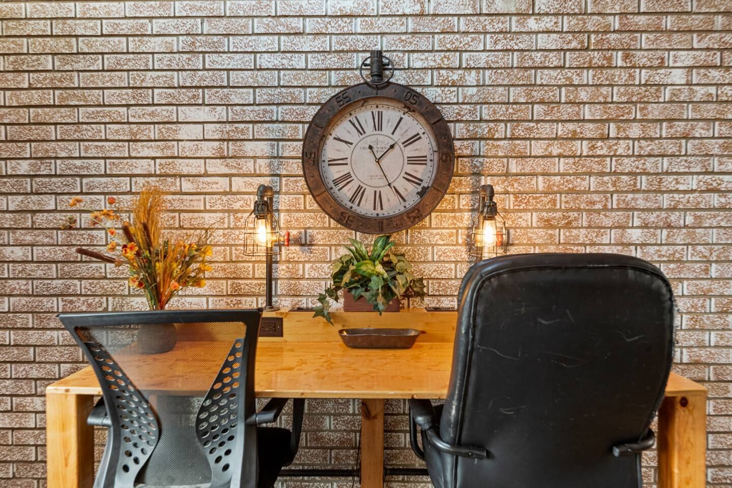 There is a clock on the wall above the desk.