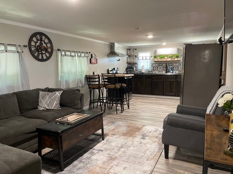 A living room filled with furniture and a clock on the wall.