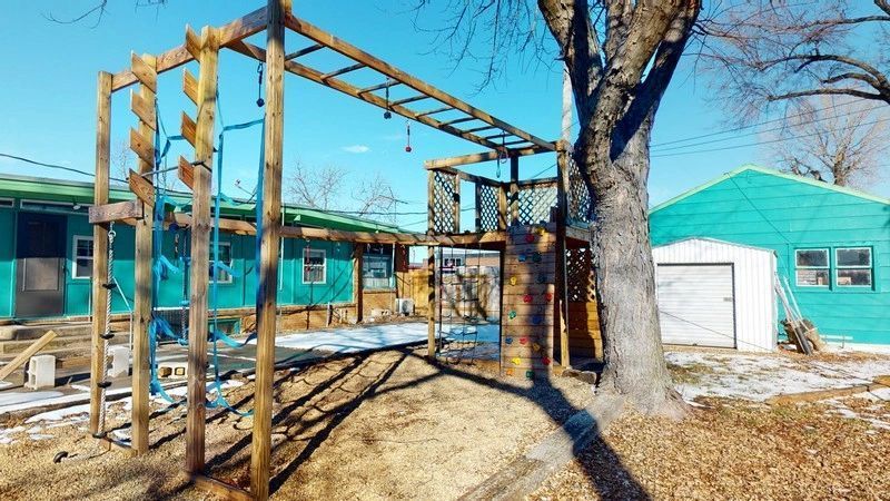 A wooden playground is being built in front of a house.