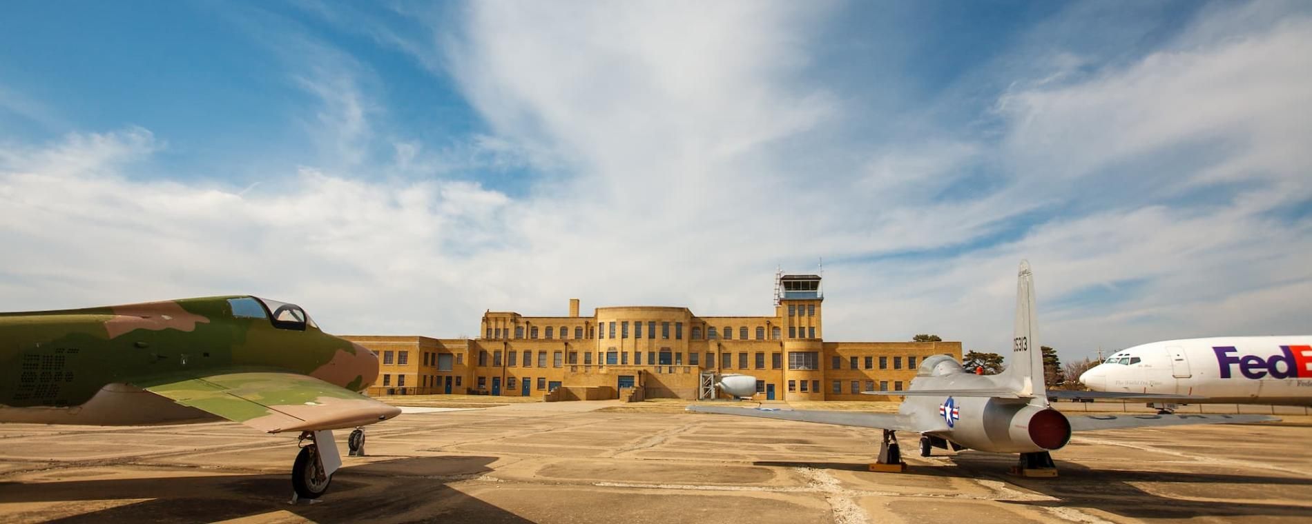 A fedex plane is parked in front of a building.