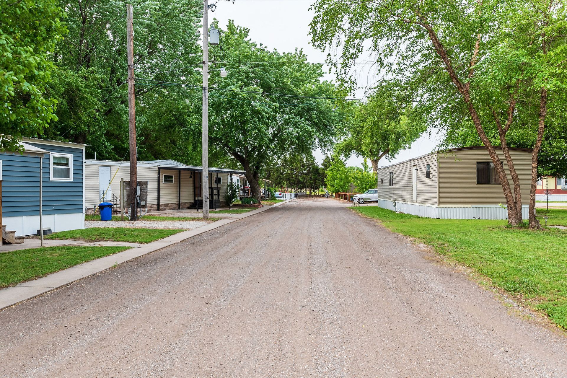 A dirt road going through a mobile home park.