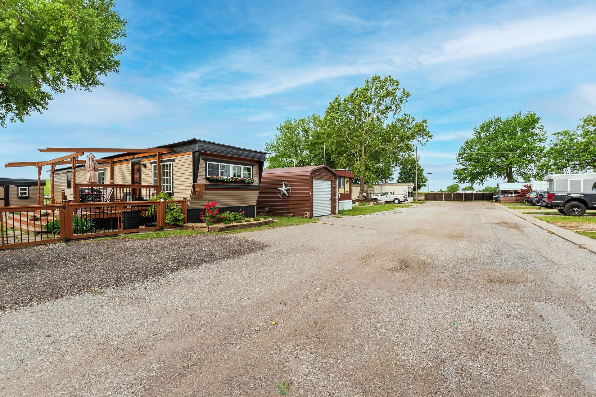 A mobile home is parked on the side of a gravel road.