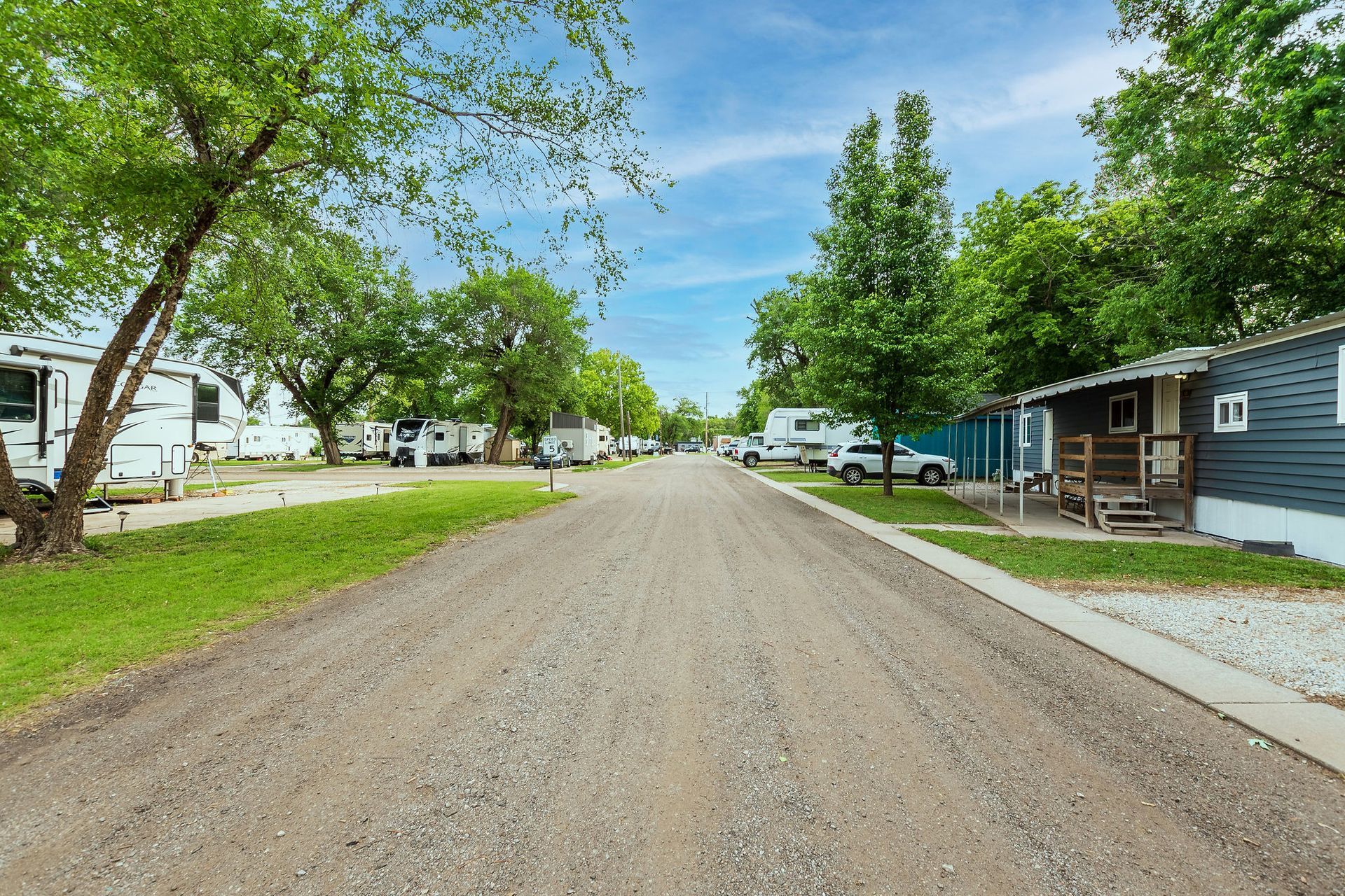 A dirt road going through a mobile home park.