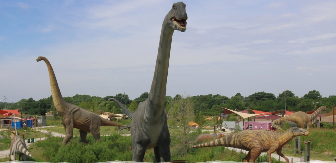 A group of dinosaurs standing next to each other in a field.