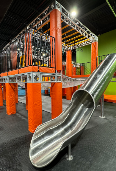 There is a slide in the middle of a playground.