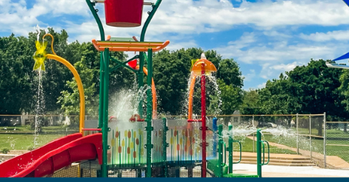 A water park with a slide and buckets spraying water
