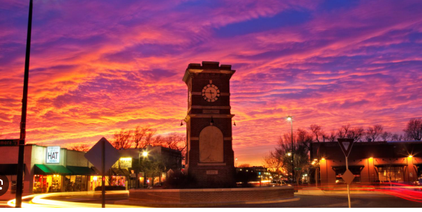 A clock tower with a sunset in the background