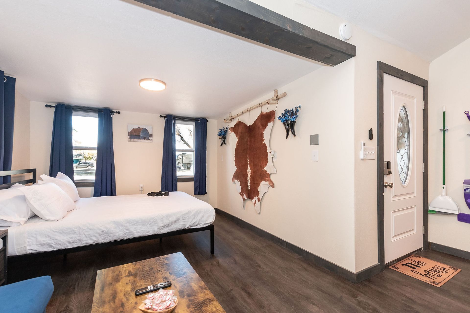 A bedroom with a bed , coffee table , window and door.