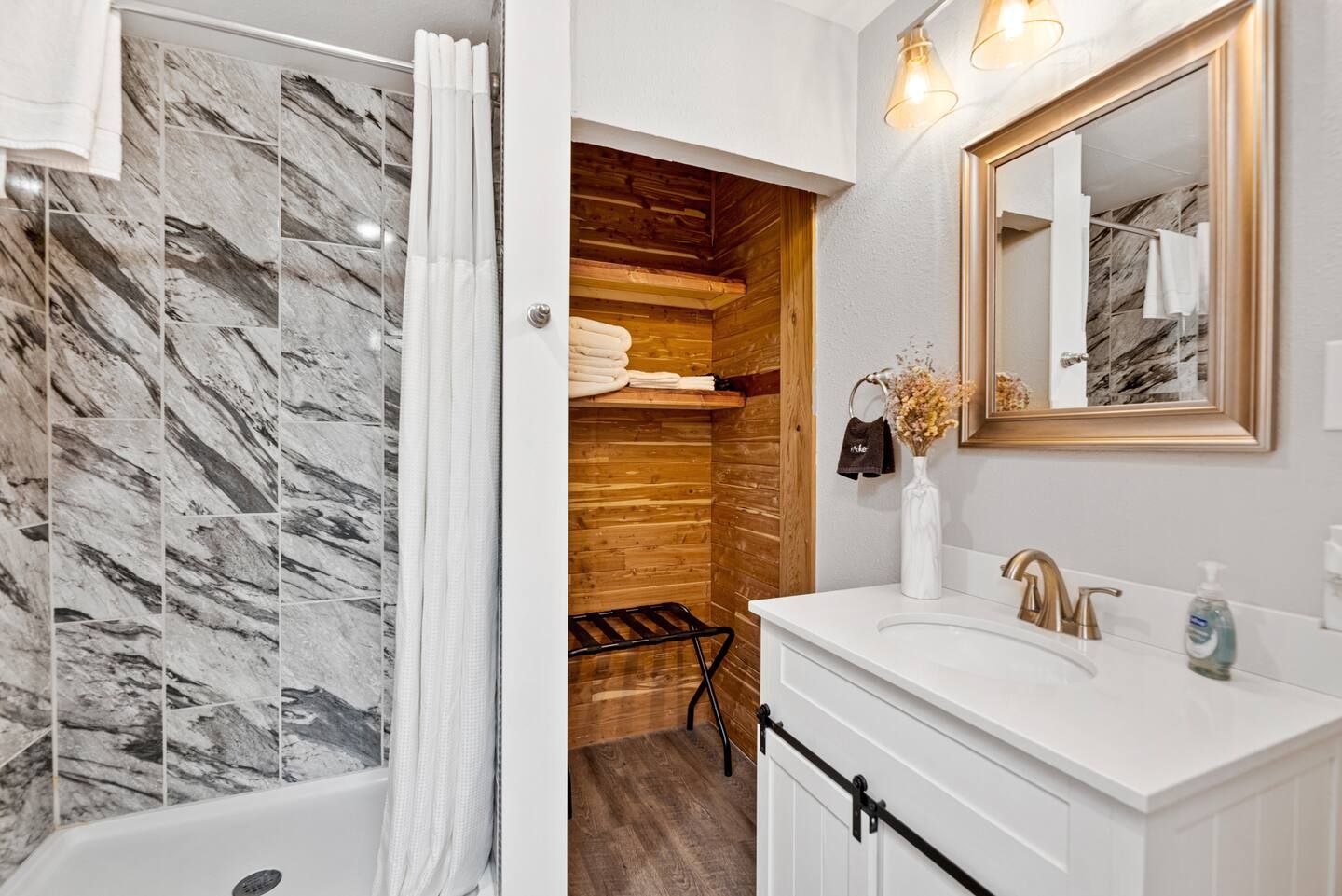 A bathroom with a sink , mirror , tub and shower.