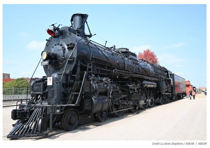 A black train is parked on the side of the road.