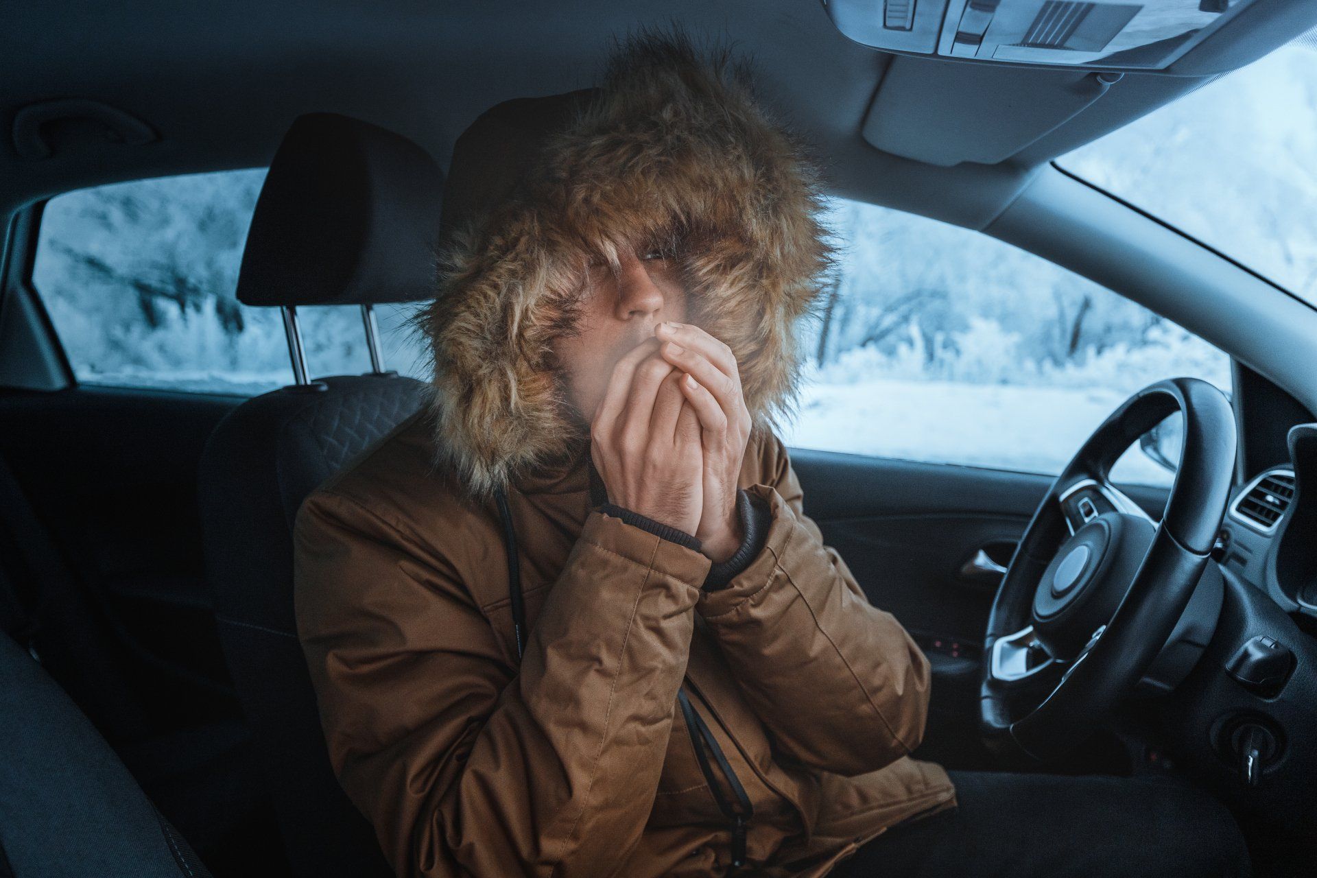 Man trying to keep warm in a cold car