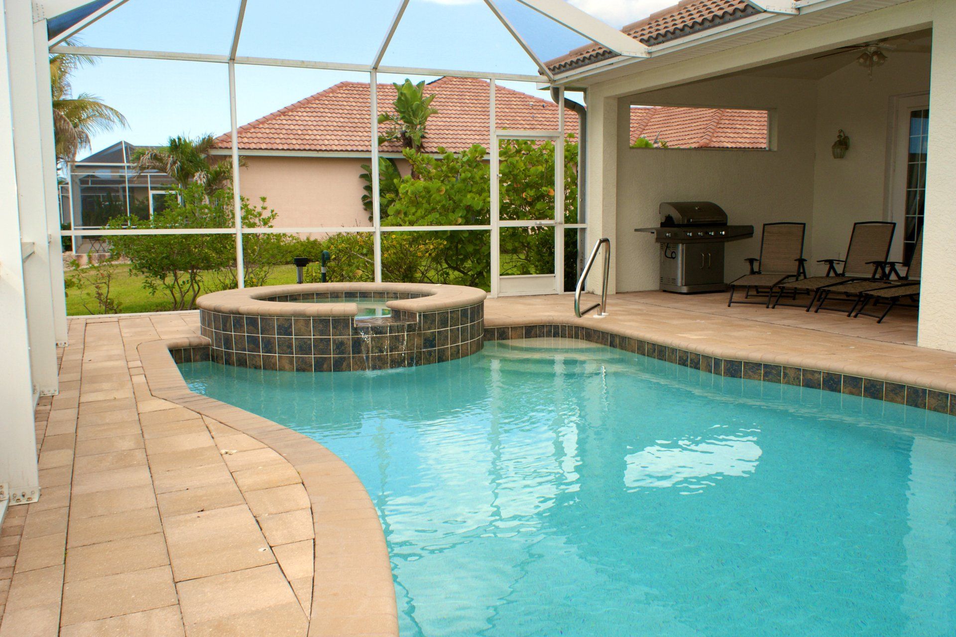 Sparkling pool and spa under a pool cage in a custom built home in Florida