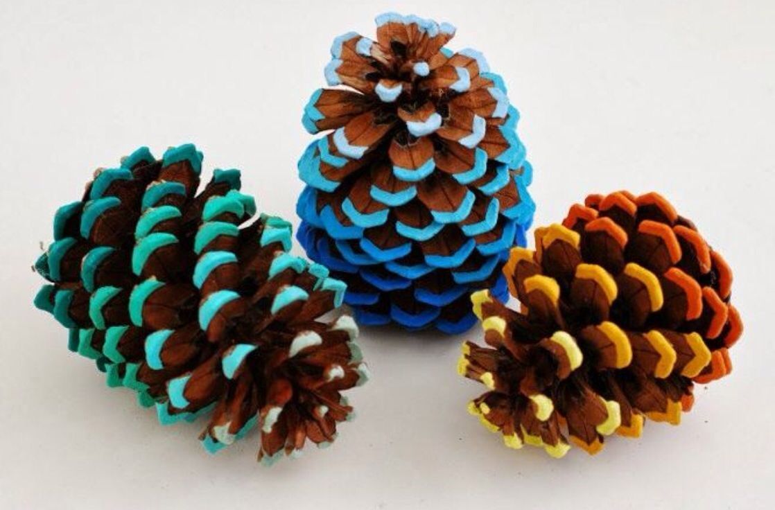 Three pine cones with different colors painted on them