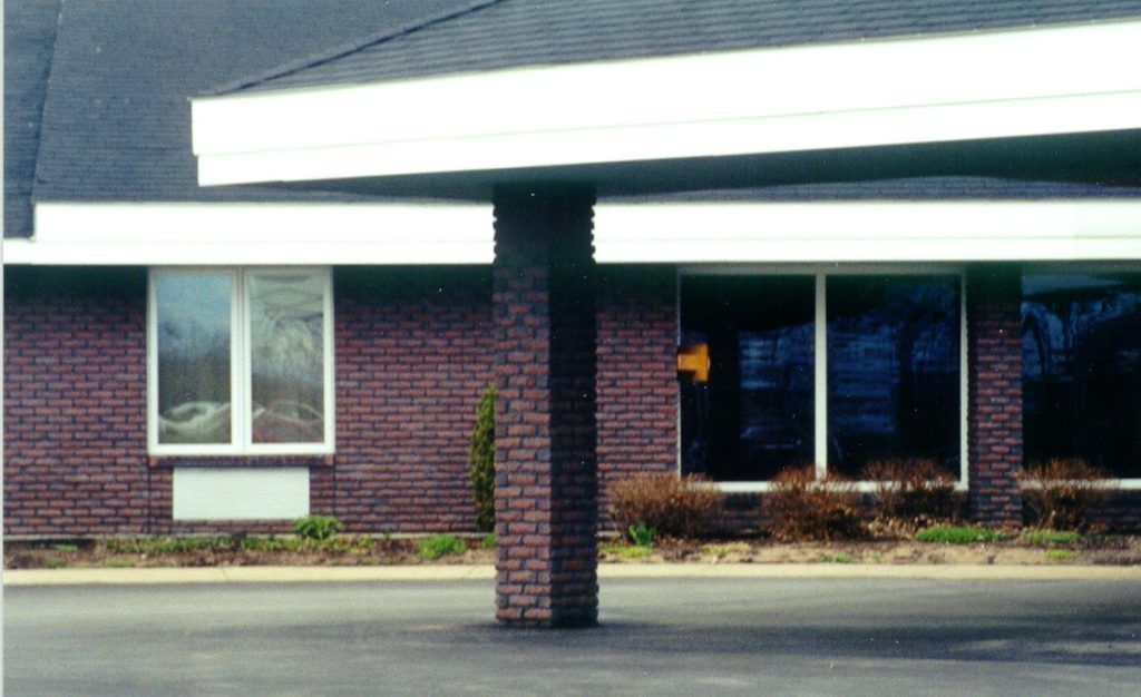 A brick building with a pillar in front of it