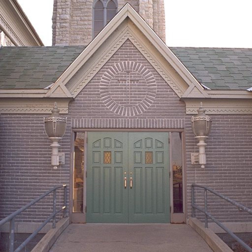 The front of a church with a green door