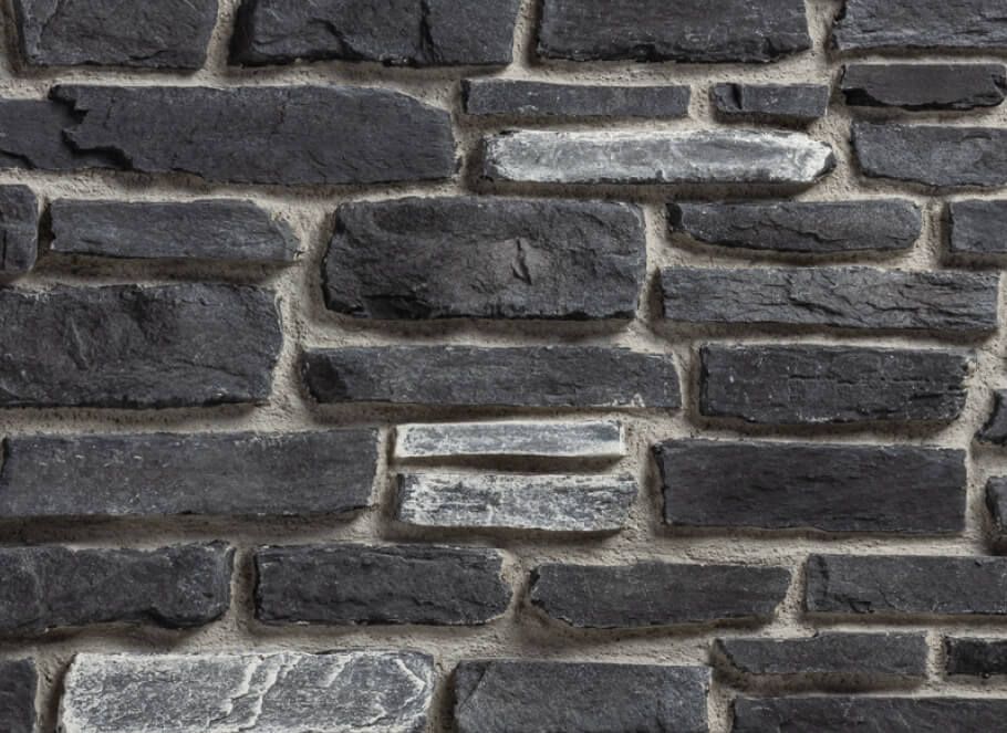 A close up of a black stone wall