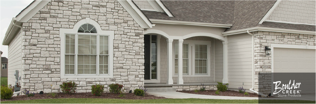 A white house with a stone facade and arched windows