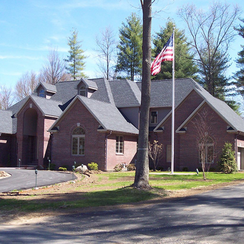 A large brick house with an american flag in front of it