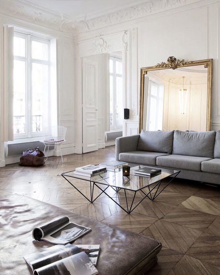 A living room with a couch , coffee table , and mirror.