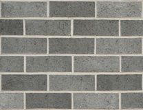 A close up of a brick wall with gray and white bricks.