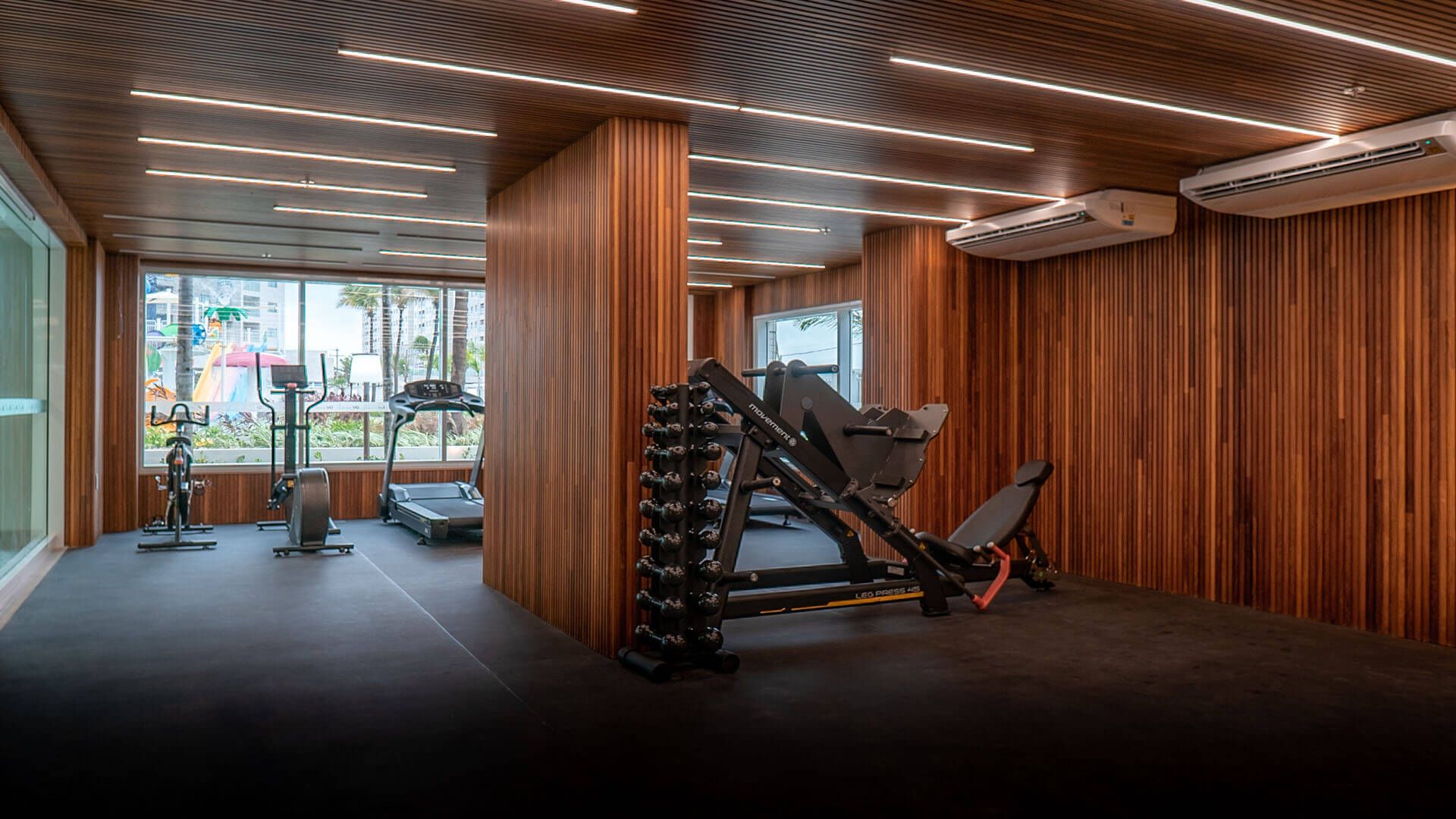Uma grande academia com paredes de madeira e uma esteira.