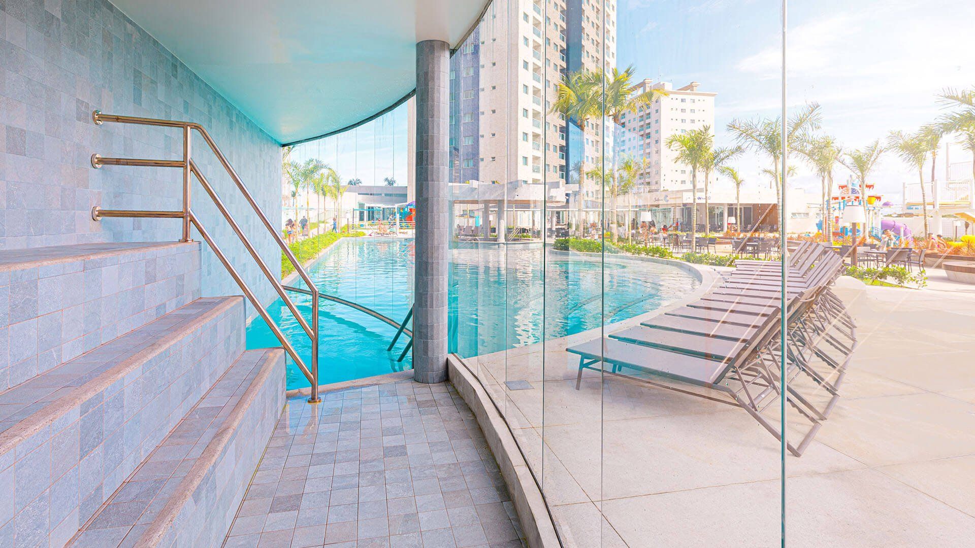 Uma vista de uma piscina através de uma parede de vidro.