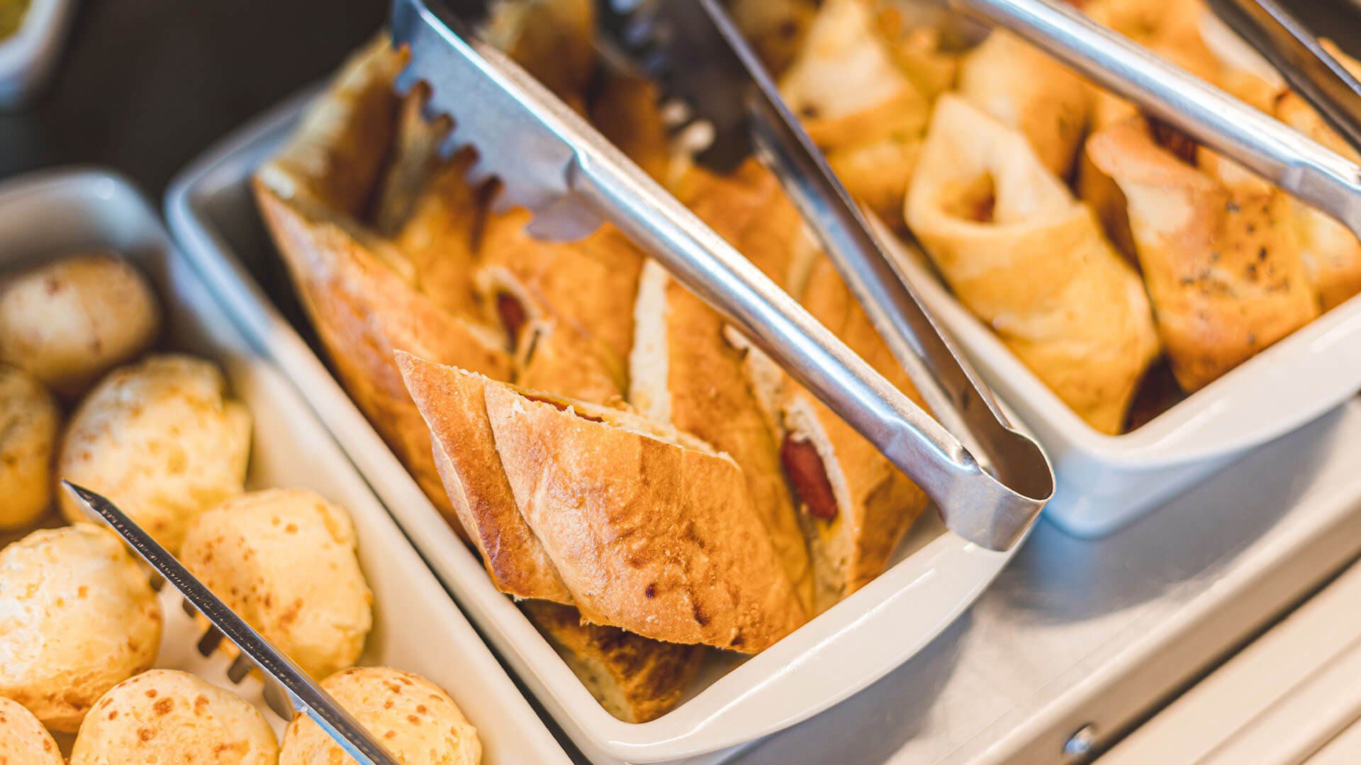 Um close de uma bandeja de comida com pinças sobre uma mesa.