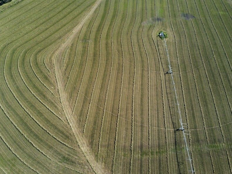 An Aerial View Of A Tractor Plowing A Field Of Grass — Kingaroy Crane Trucks & Equipment Hire In Goomeri, QLD