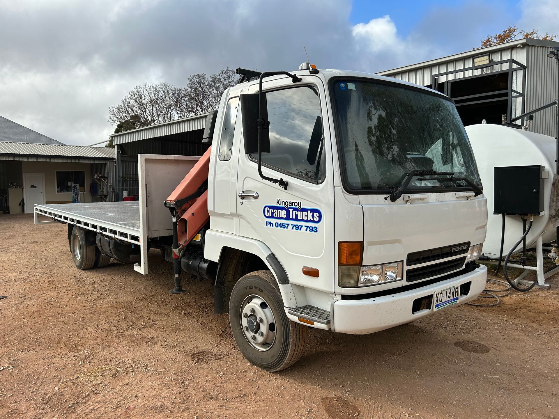 A White Tow Truck Is Carrying A Green Tractor — Kingaroy Crane Trucks & Equipment Hire In Kingaroy, QLD