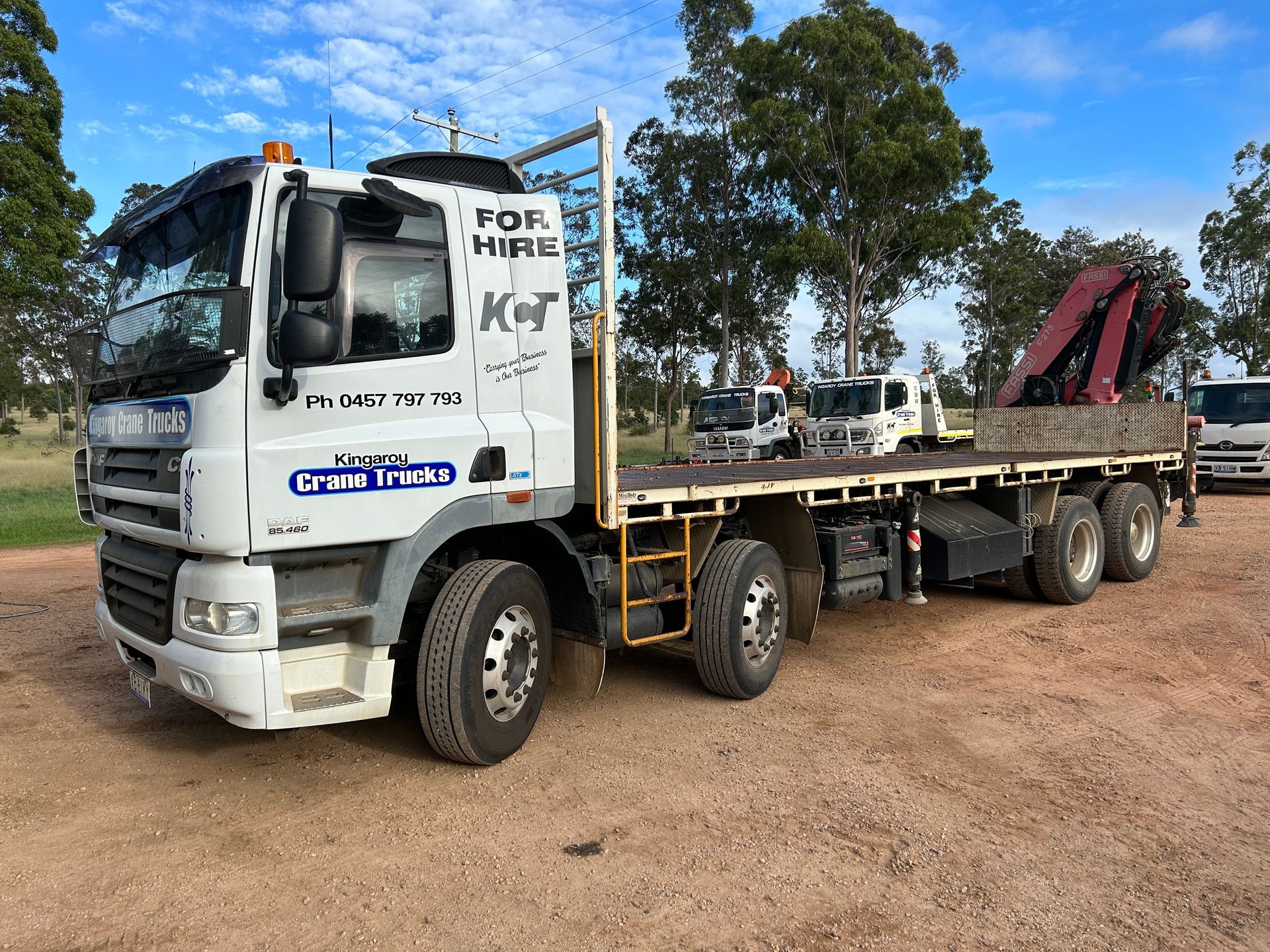 A White Truck With An Excavator On The Back Of It — Kingaroy Crane Trucks & Equipment Hire In Kingaroy, QLD