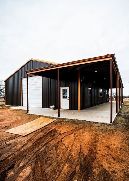 Brown metal building with attached covered patio, white door, and concrete slab.