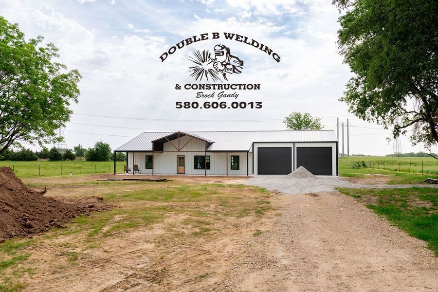 Building with Double B Welding & Construction logo, phone number, and a newly constructed white building with gray garage doors.