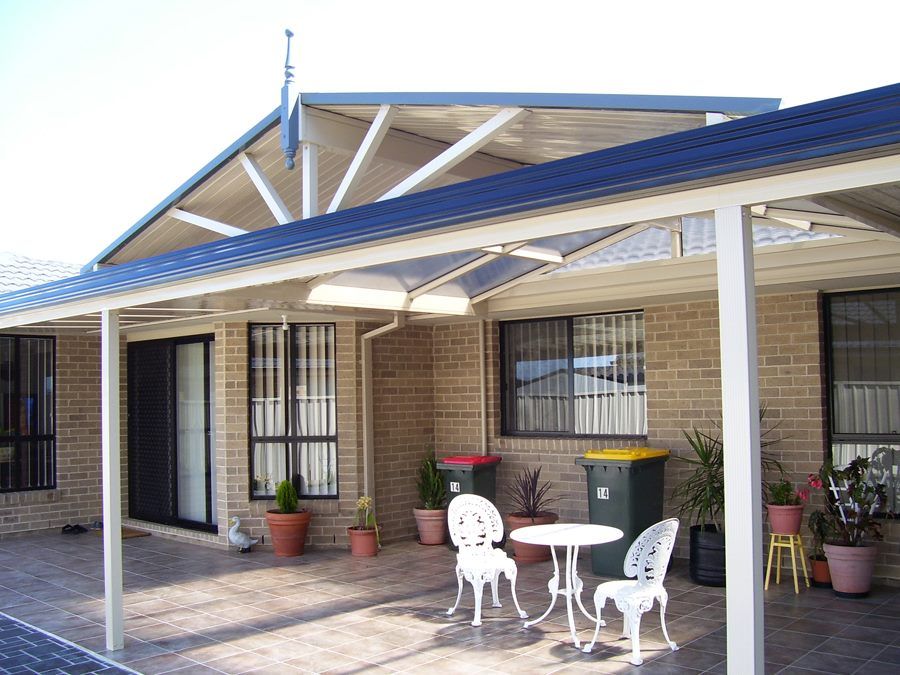 A porch with a table and chairs under a blue roof