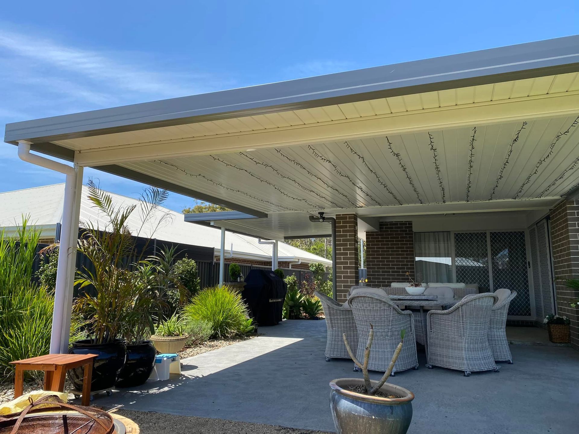 A patio with a table and chairs under a canopy.
