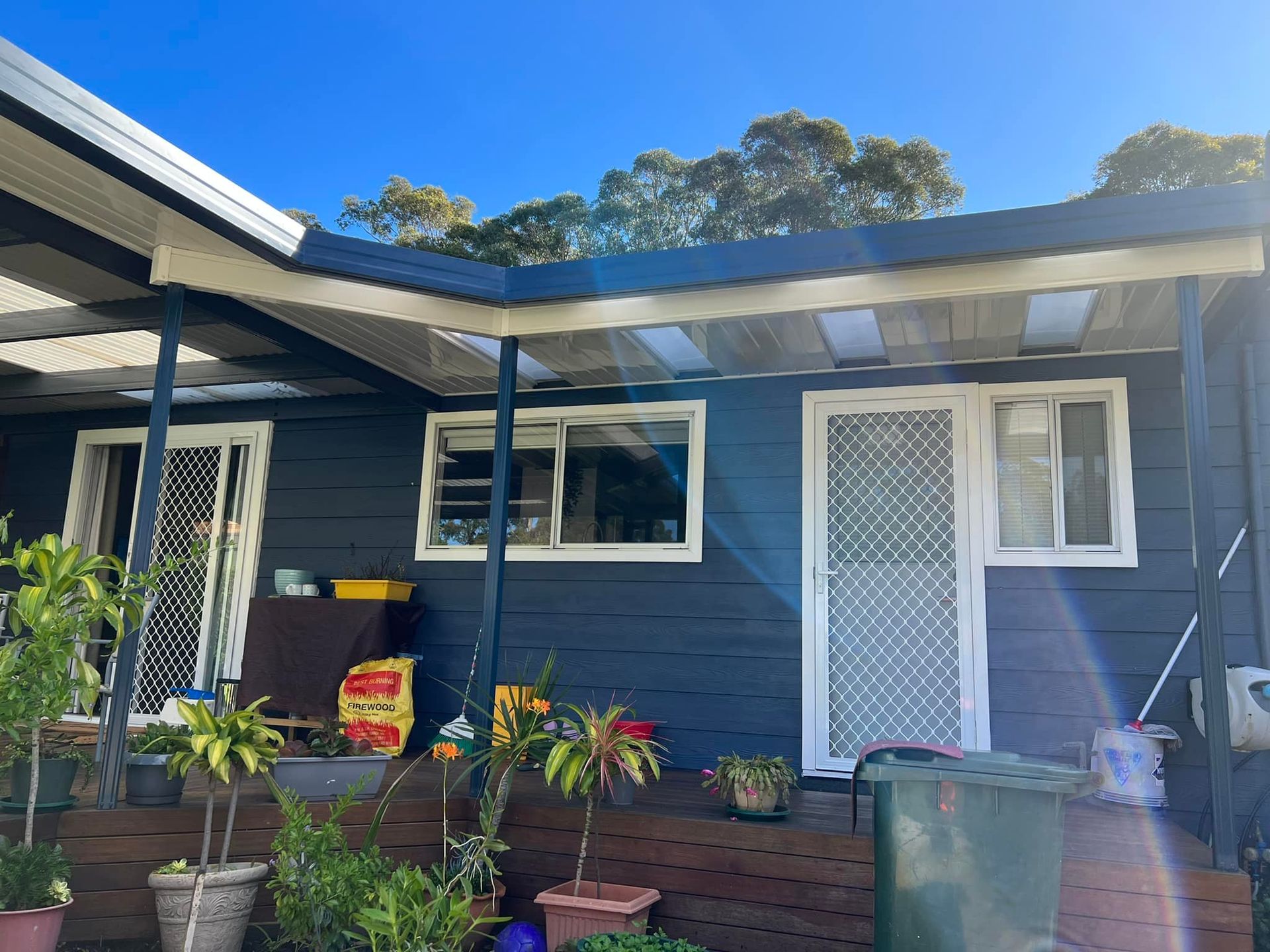 A small house with a porch and a blue sky in the background.