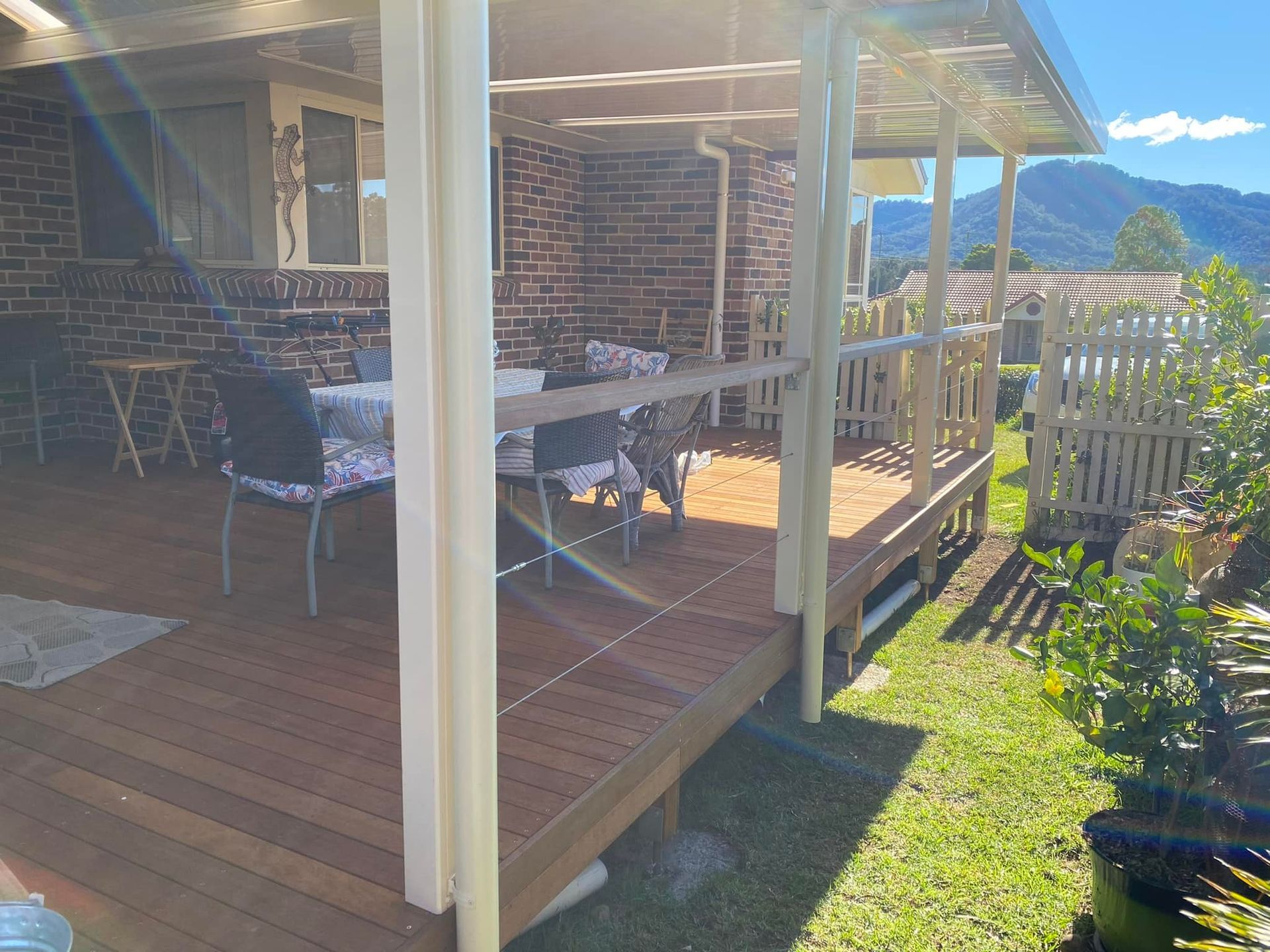 There is a wooden deck with a table and chairs on it.
