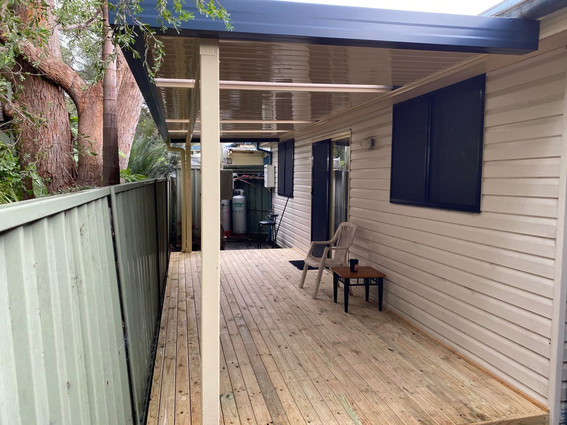 A wooden deck with a chair and a table on it