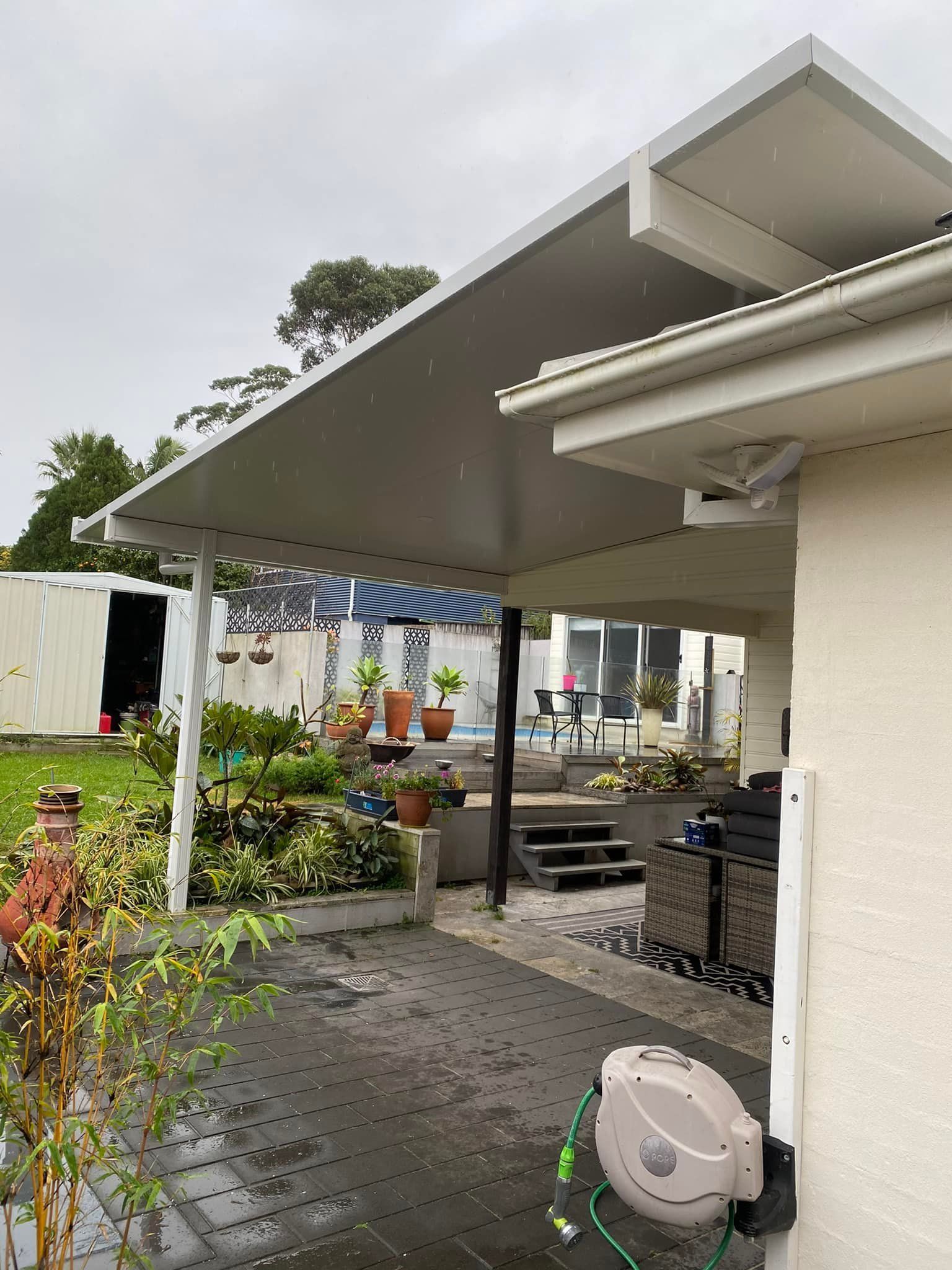 A white house with a covered patio in the backyard.