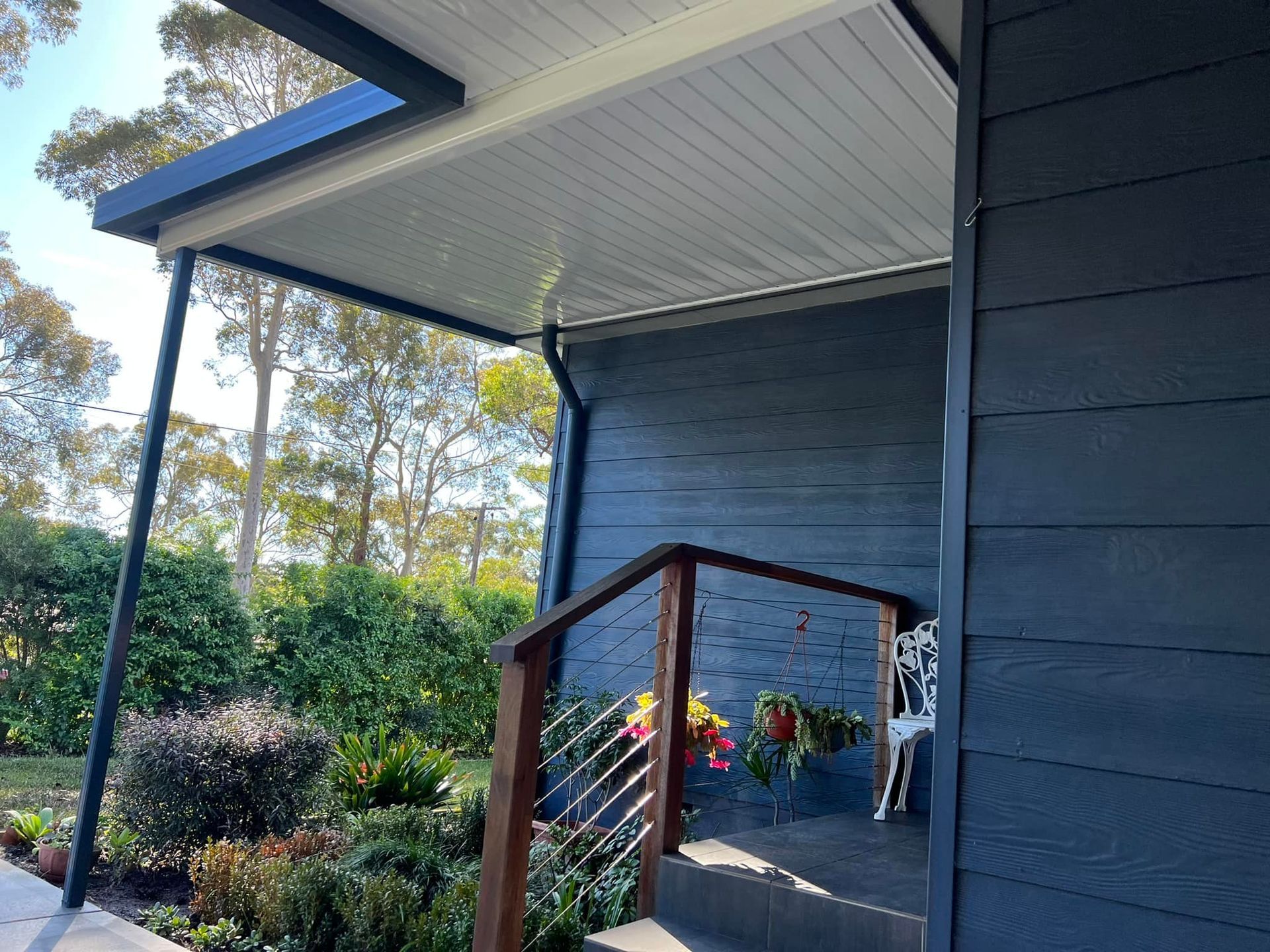 A blue house with a porch and stairs leading up to it.