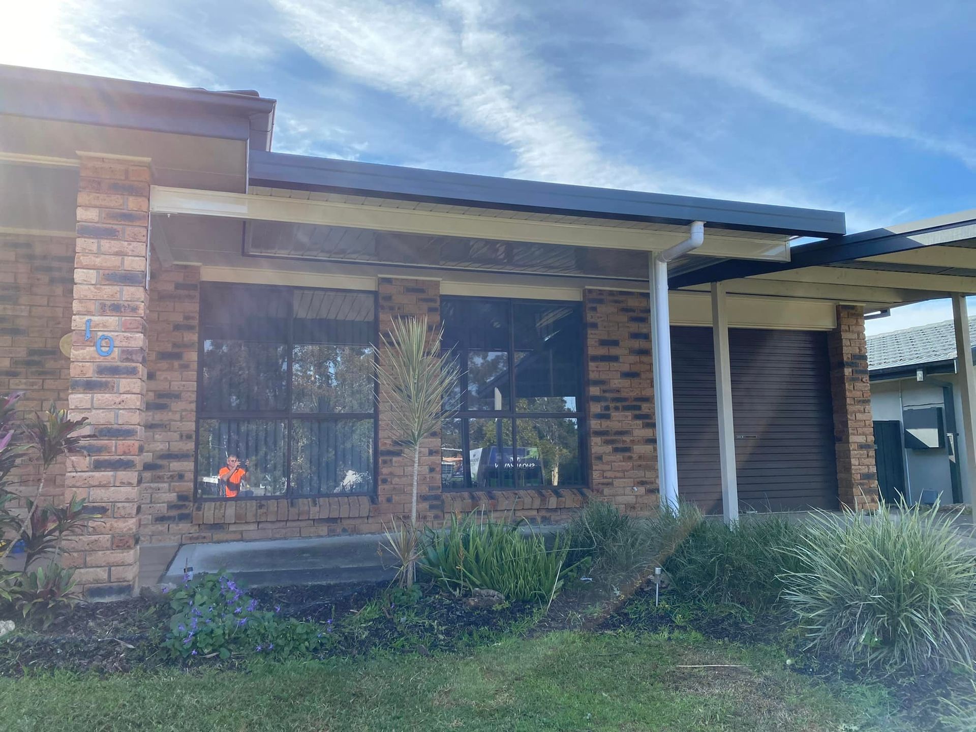 A brick house with a covered porch and a lot of windows.