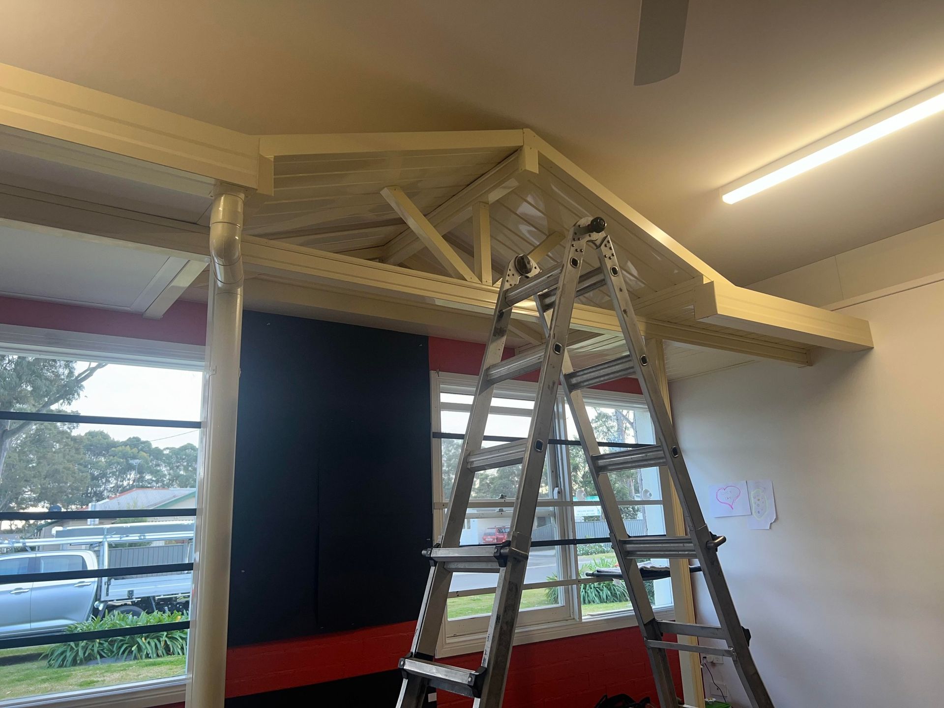 A ladder is sitting on top of a wooden structure in a room.